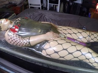 View Miss Maskerade in latex vacuum bed wearing a silicone female mask as a rubber doll